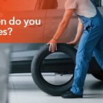 Mechanic rotating vehicle tires during routine maintenance to promote even tire wear.