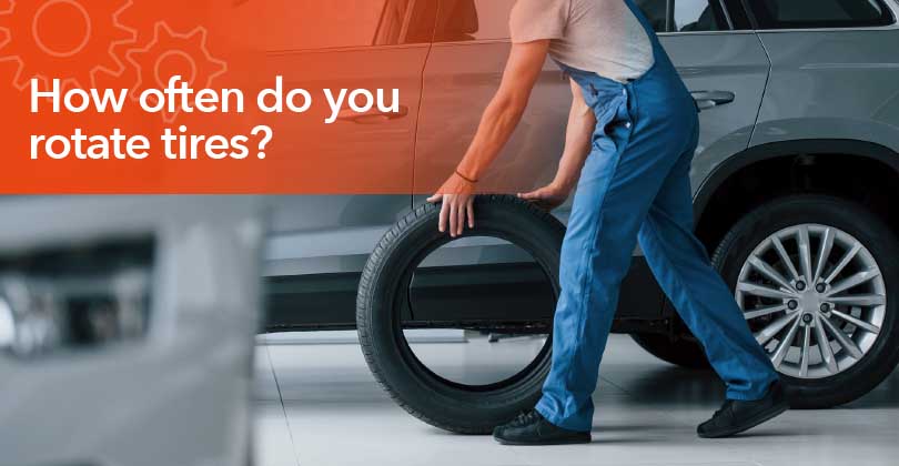 Mechanic rotating vehicle tires during routine maintenance to promote even tire wear.