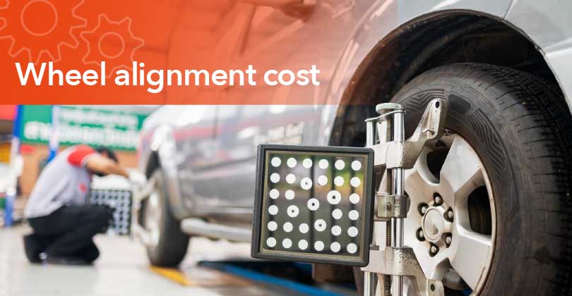 Technician performing a wheel alignment service on a vehicle using alignment equipment.