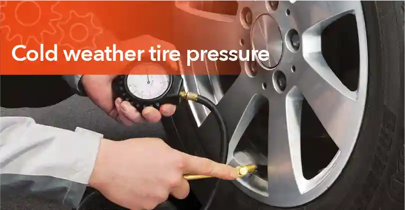 Technician checking car tire pressure during cold weather to ensure safe driving and proper tire