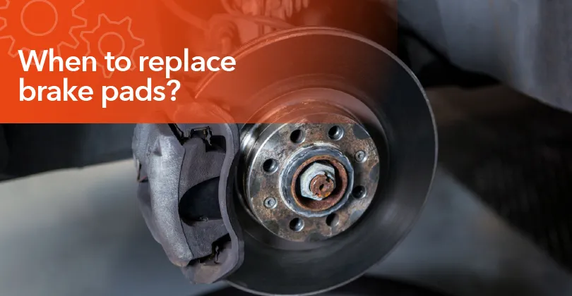 Mechanic inspecting worn brake pads during a routine vehicle brake service.
